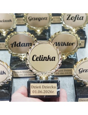 złota statuetka na dzień dziecka z dwiema tabliczkami na marmurowej podstawie